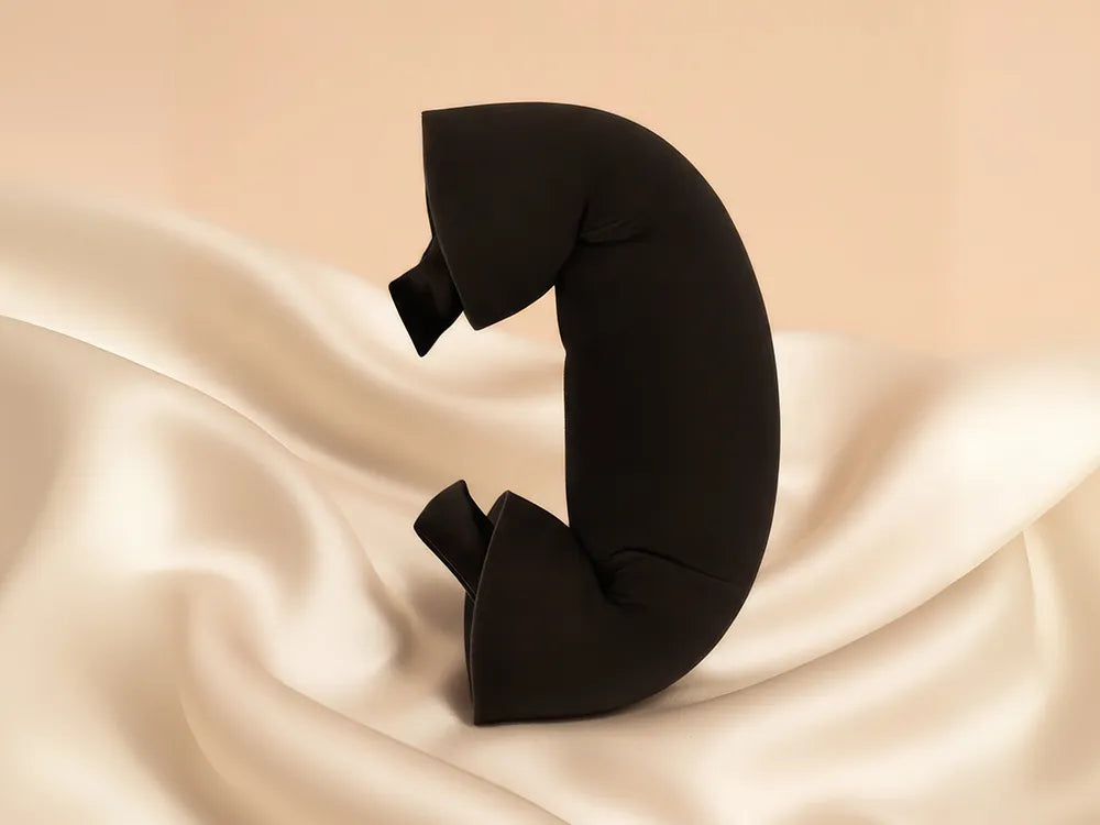 Black neck pillow on a beige fabric background
