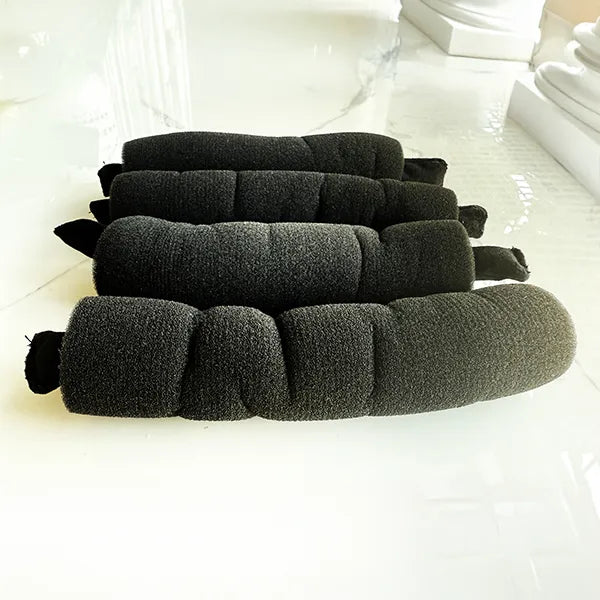 Stack of black foam rollers on a white surface