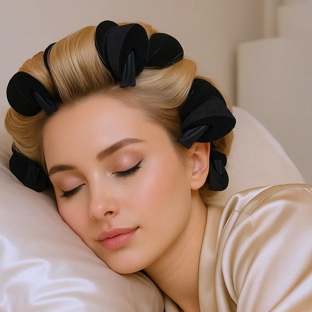 Woman with hair in rollers lying on a pillow, wearing a beige robe.